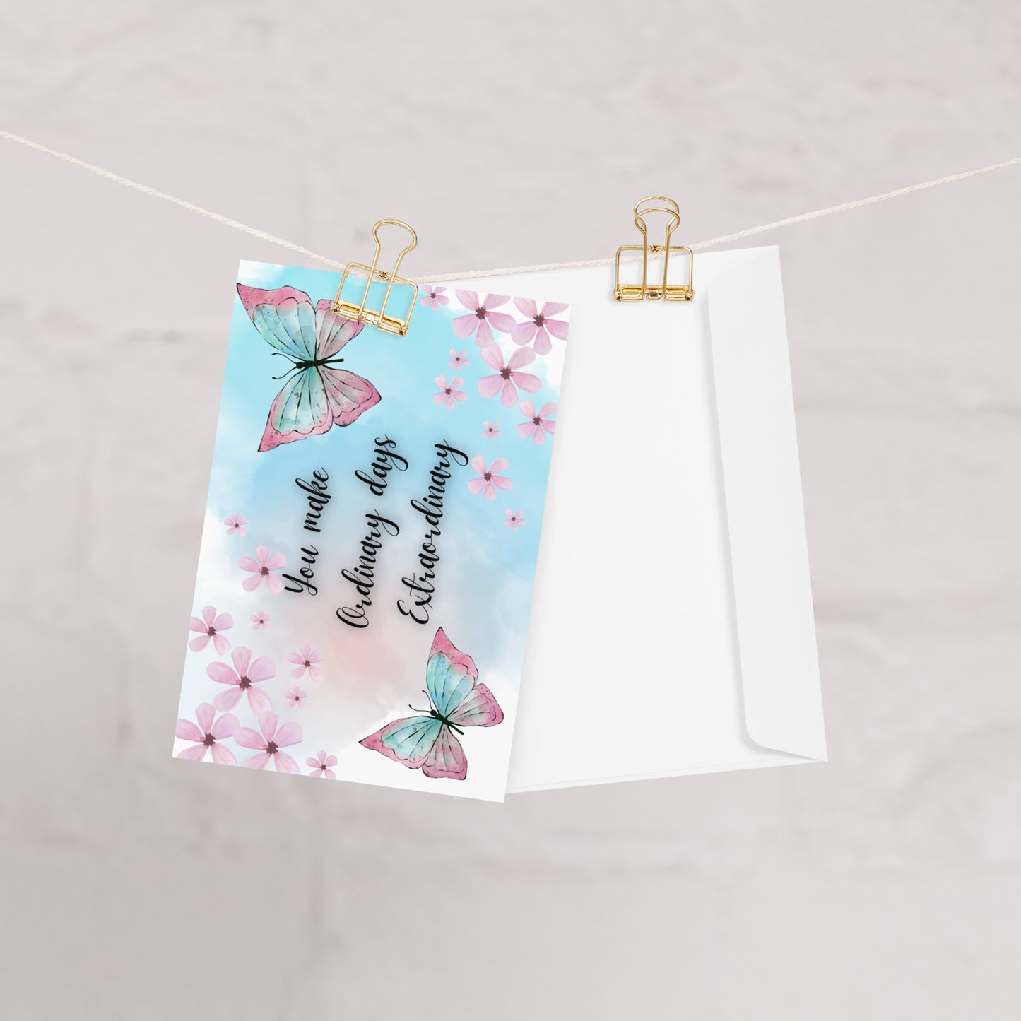 Greeting card with butterflies and floral design on a string with clips.