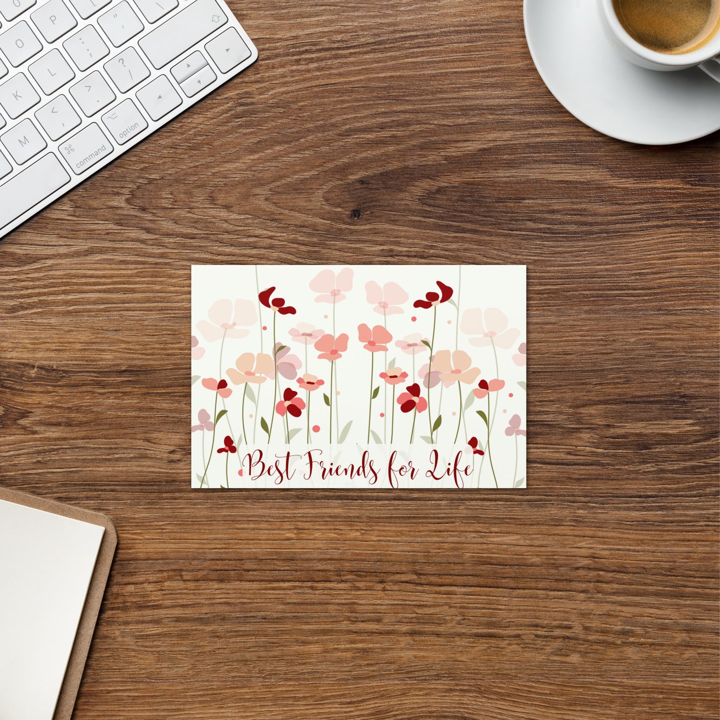 Floral card with 'Best Friends for Life' on a wooden desk with a keyboard and coffee cup.