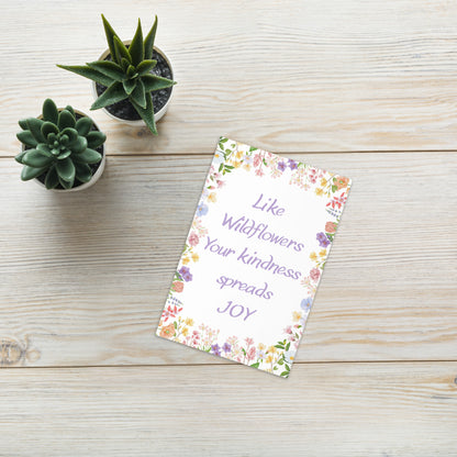 Notebook with motivational quote on a wooden surface with succulents
