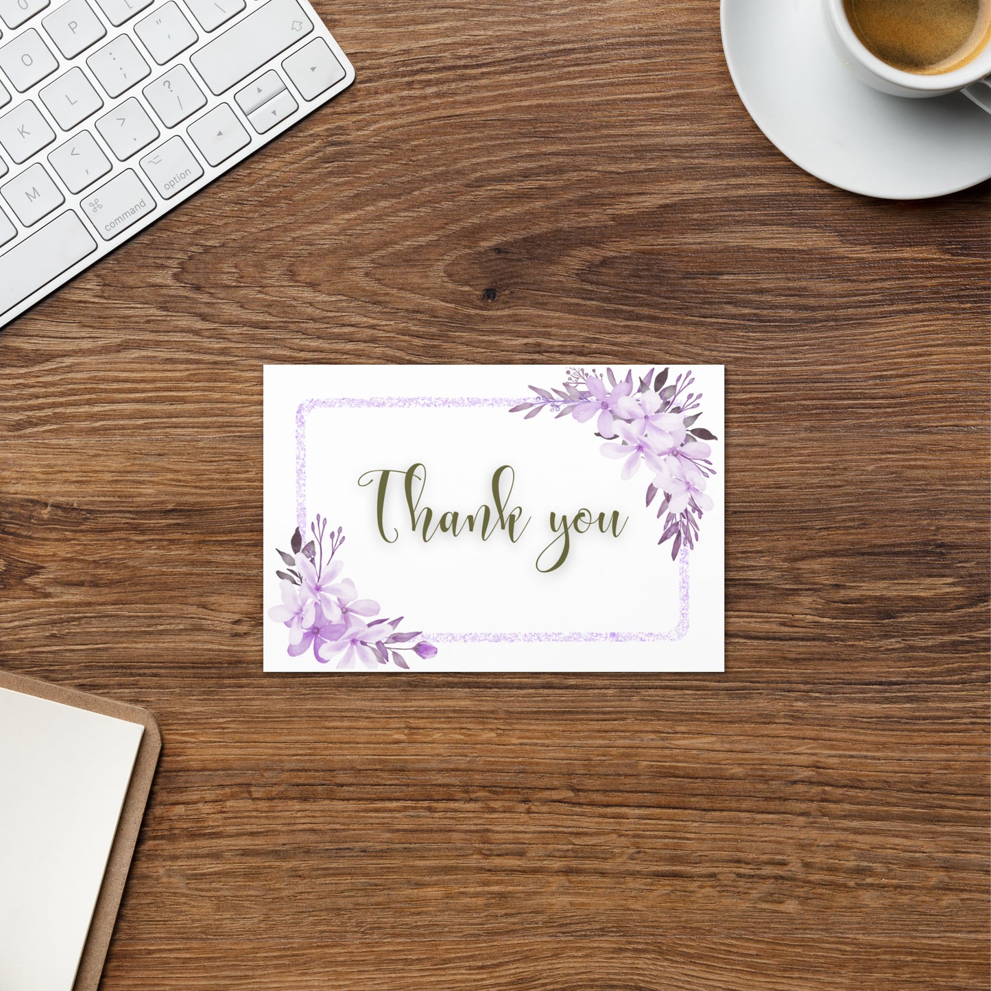 Note card with 'Thank you' on a wooden desk with a keyboard and coffee cup.