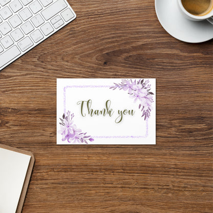 Note card with 'Thank you' on a wooden desk with a keyboard and coffee cup.