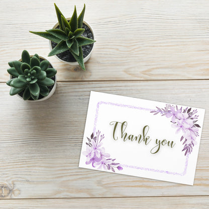 Greeting card with 'Thank you' text on a wooden surface with potted plants.