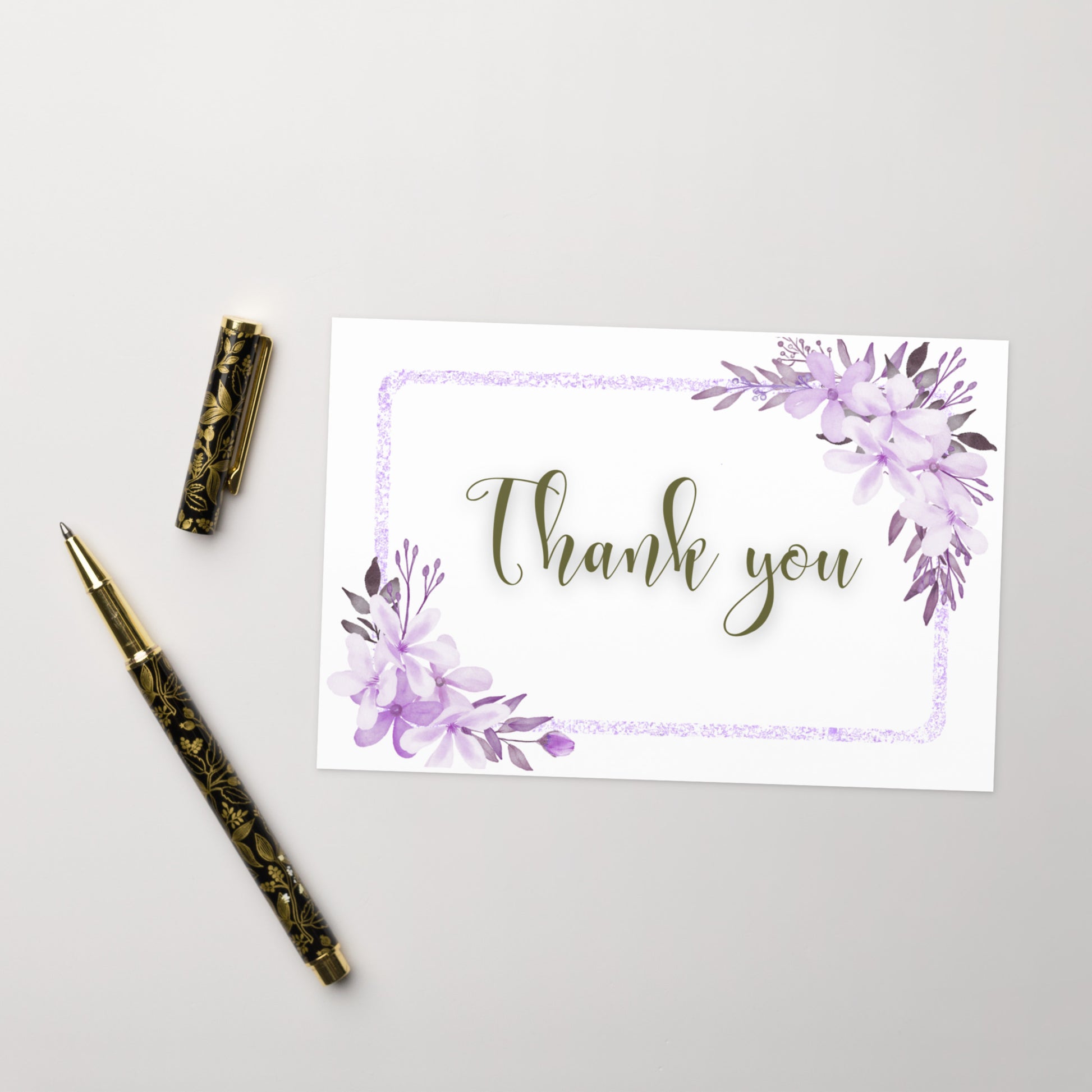 Greeting card with 'Thank you' text and floral design on a white background, accompanied by a decorative pen.