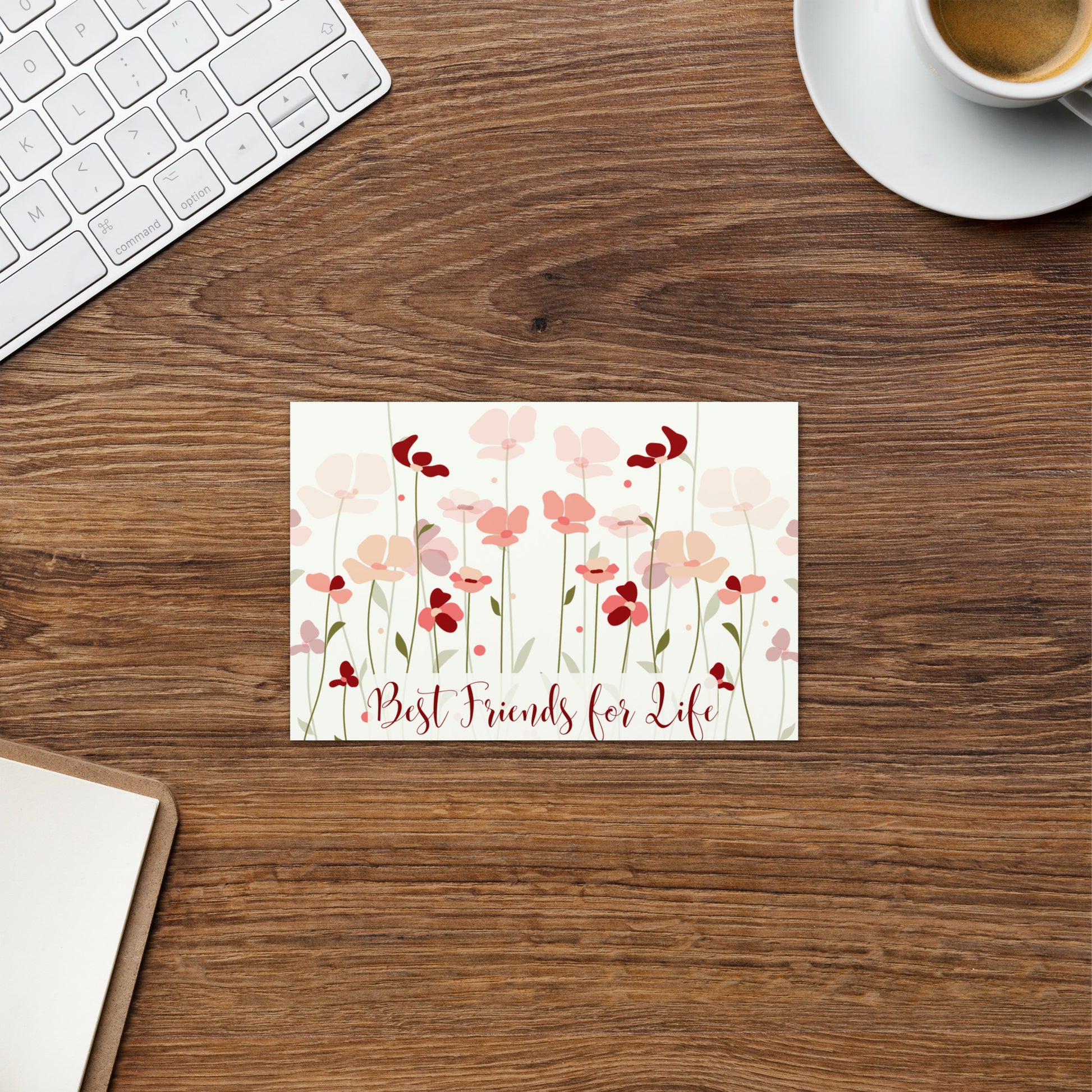 Floral card with 'Best Friends for Life' on a wooden desk with a keyboard and coffee cup.