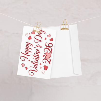 Valentine's Day card with red text and hearts on a white background, clipped to a string.
