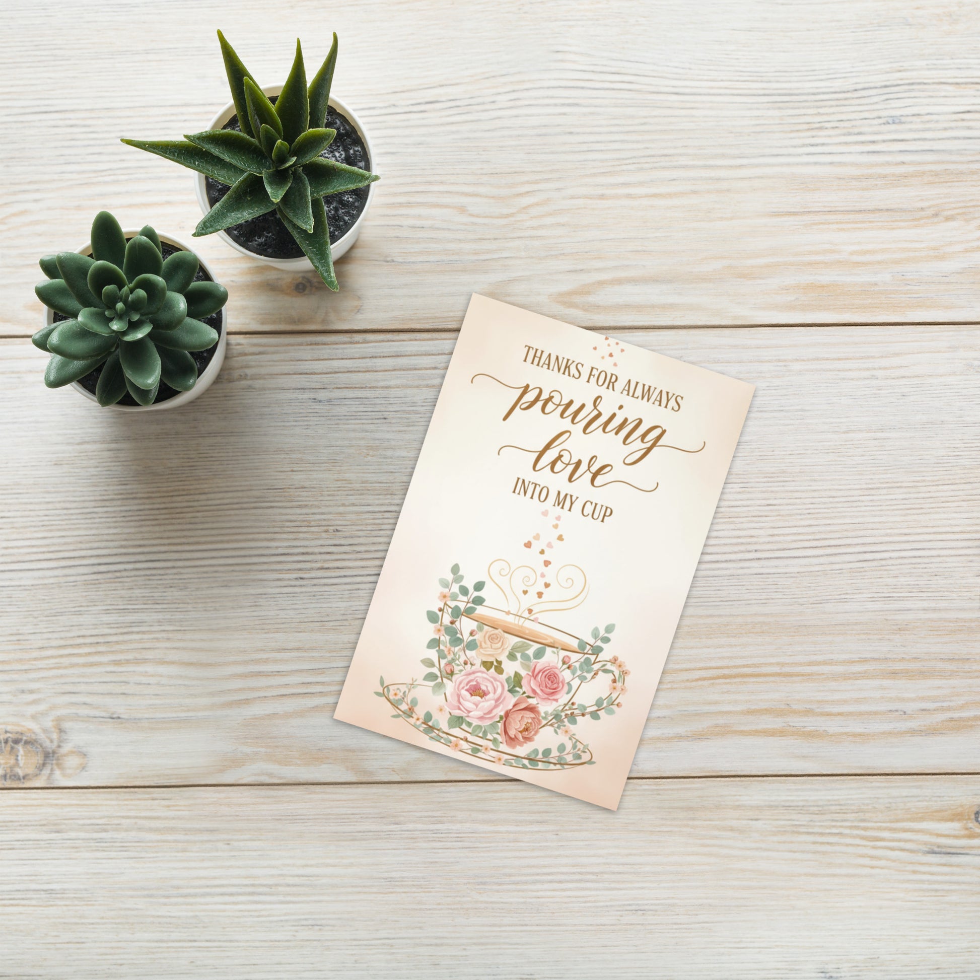 Greeting card with floral design and text on a wooden surface with potted plants.