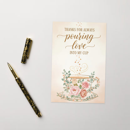 Greeting card with floral design and pen on a light gray background