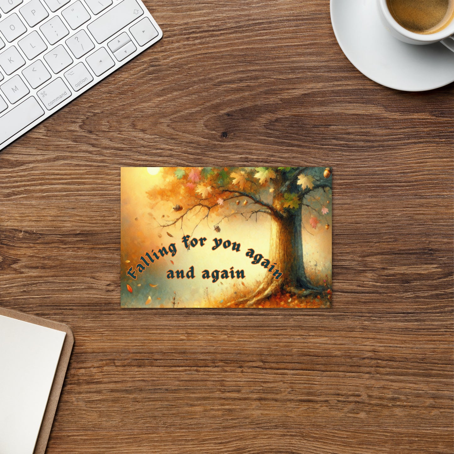 Desk with a decorative card featuring an autumn tree and text, a keyboard, and a cup of coffee.