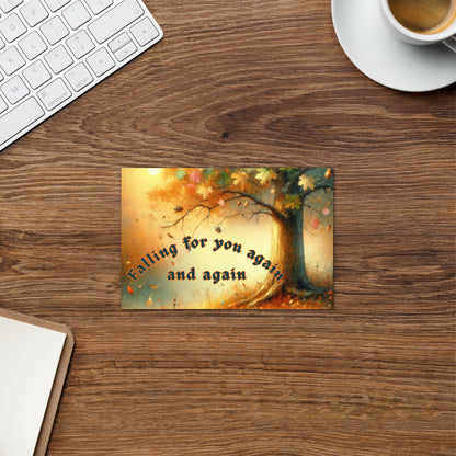 Desk with a decorative card featuring an autumn tree and text, a keyboard, and a cup of coffee.