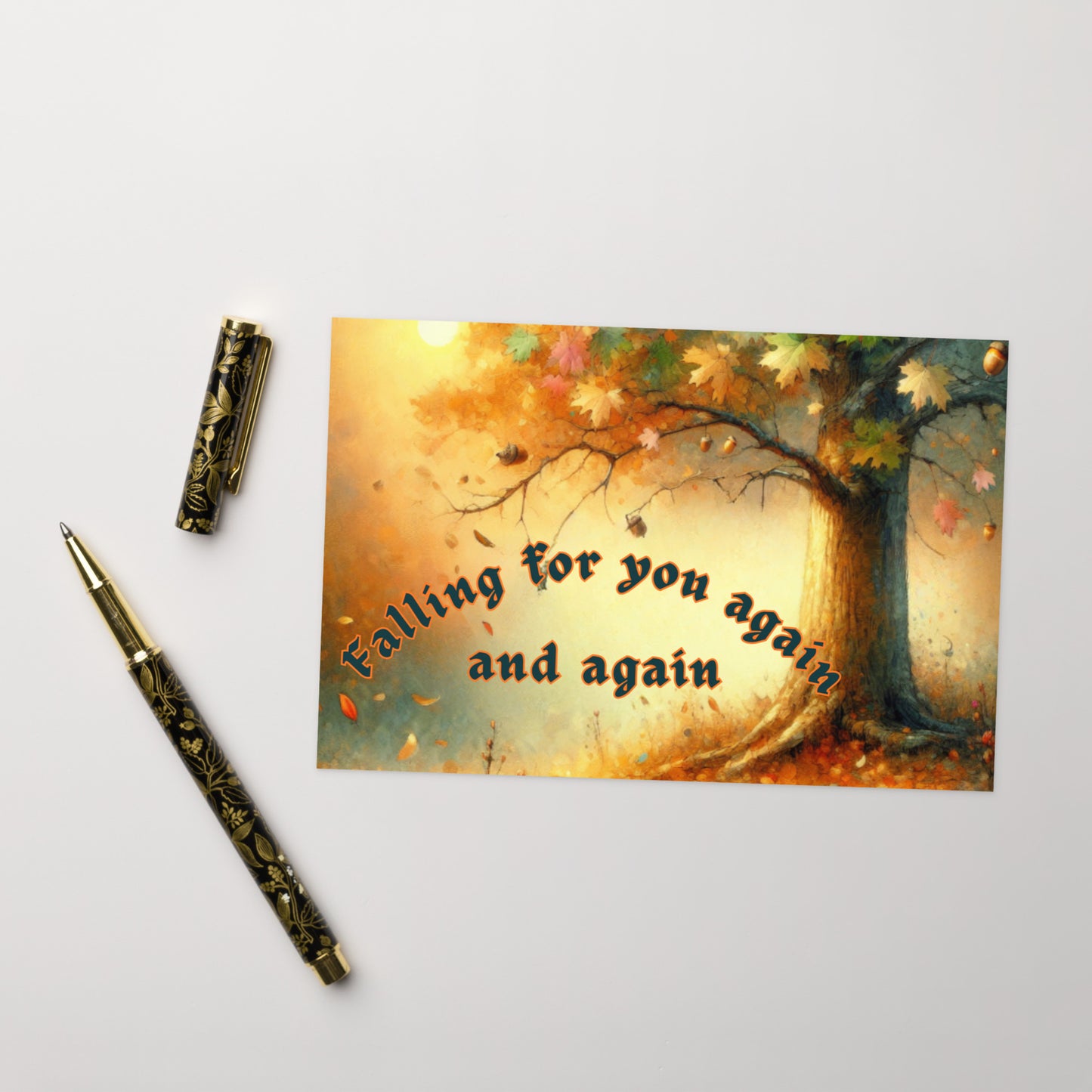 Greeting card with autumn tree design and text 'Falling for you again and again' on a white background with a pen.